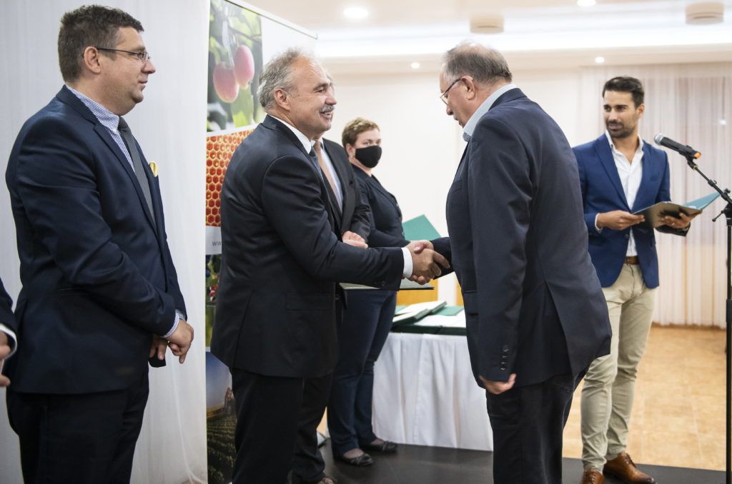 Sikeres pályázatok Szabolcs-Szatmár-Bereg megyében: több mint 24,5 milliárd forintot ítéltek oda a kedvezményezetteknek - Nagy István agrárminiszter (középen) átadja az okiratot Bárány Lászlónak, a Baromfi-Coop Termelő és Kereskedelmi Kft. ügyvezetőjének (j) az állattartó telepek korszerűsítésére kiírt pályázat támogatói okiratainak átadásán a Szabolcs-Szatmár-Bereg megyei Napkoron 2021. május 18-án. Balról Seszták Miklós országgyűlési képviselő. MTI/Balázs Attila