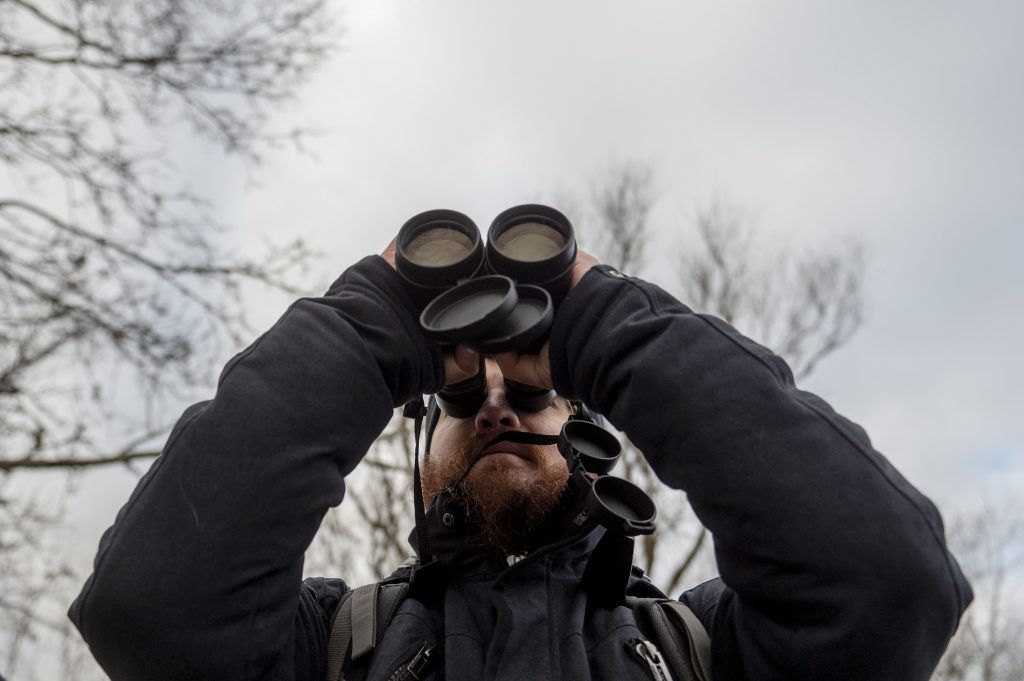 Zelenák Attila, a Magyar Madártani és Természetvédelmi Egyesület munkatársa távcsővel a kezében Jászberény közelében 2024. január 13-án - Fotó: MTI/Komka Péter
